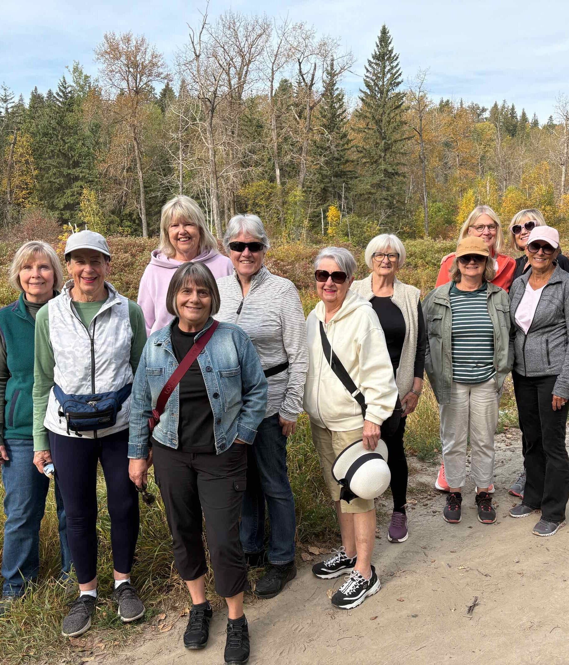 Edmonton Newcomers & Friends - A group of women standing on a path outside in front of trees changing colour